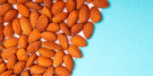 A spread of Vitamin E-rich foods like almonds and sunflower seeds on a wooden table.