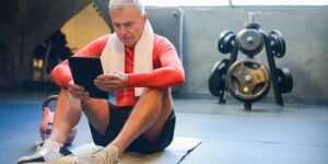 An active senior performing a seated torso rotation exercise on a sturdy chair.
