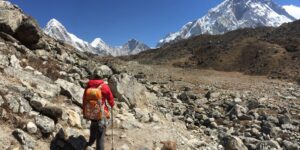Minimalist travel gear for high-altitude trips including a backpack and walking poles.