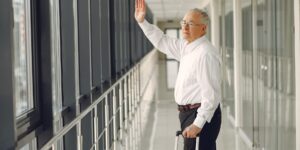 A confident senior traveler walking through a modern airport terminal.
