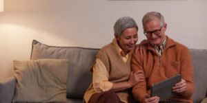 An older couple using a tablet to explore digital museum exhibits in a gallery.
