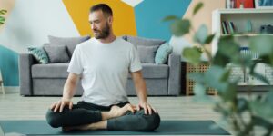 A person practicing seated posture exercises in a well-lit living room.