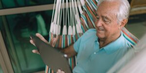 An older adult practicing seated posture in a comfortable home setting.