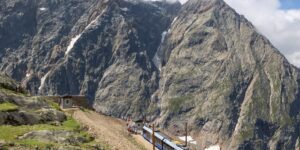 Modern mountain railway train climbing an alpine slope.