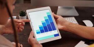 A senior couple reviewing smart-home energy data on a tablet in a sunny living room.