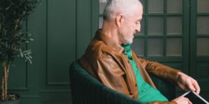 A senior sitting comfortably in an ergonomic chair, representing spinal health.