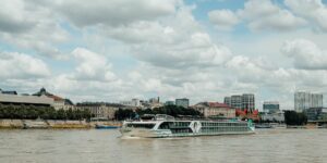 A scenic view of a river cruise ship on a calm river.