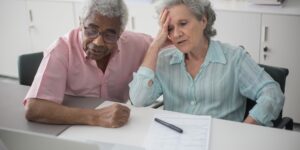 A senior couple reviewing health information on a tablet in a well-lit, modern room.