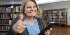 A senior individual reading an e-book in a comfortable library lounge.