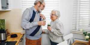 An older couple enjoying a Vitamin B12-rich meal in a sunlit kitchen.