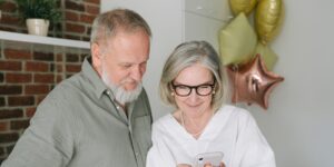 A senior couple using a smartphone to navigate a city street.