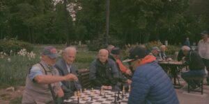 A diverse group of seniors playing chess in a community center.
