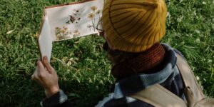 A person sketching a bird in a tranquil garden setting.