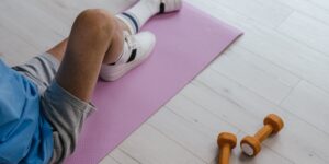 An active senior performing gentle wrist mobility exercises in a well-lit, comfortable workspace.