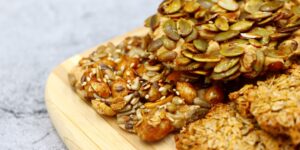 A selection of copper-rich whole foods like nuts, seeds, and legumes arranged on a wooden surface.