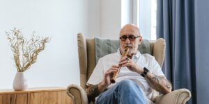A senior adult performing seated exercises in a comfortable home environment.
