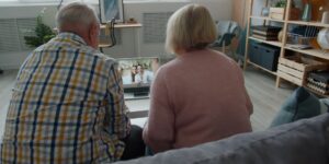 A senior adult engaging in digital photo restoration on a computer.