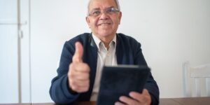 A person in their 60s confidently using a tablet for digital services.