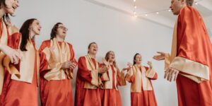 A diverse group of seniors singing together in a choir setting.