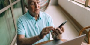 A senior adult engaged in mindful digital painting on a tablet in a cozy home environment.