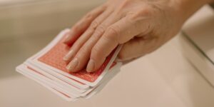 A close-up of a deck of playing cards and a scorepad on a wooden table, representing strategic leisure for seniors.