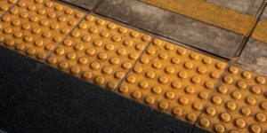 Modern transit hub platform with high-visibility yellow tactile paving.