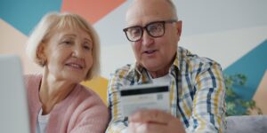 A senior couple using technology to manage their travel at an airport.