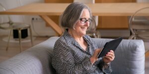 A senior adult using a tablet in a modern home setting.
