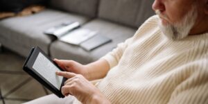 A senior adult using voice-activated technology in a comfortable home setting.