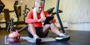 A senior adult using a digital health portal on a tablet in a comfortable home environment.
