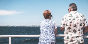 An older couple enjoying the view from the deck of a river cruise ship.