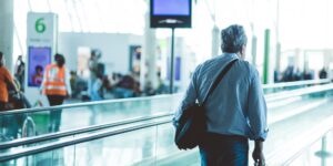 A senior couple navigating a modern airport terminal with ease.