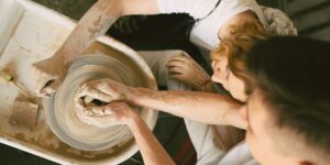 An older adult participating in a pottery workshop in a bright, accessible studio environment.