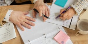 Close-up of hands using a bone folder on paper for bookbinding
