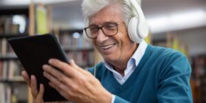 A senior adult enjoying digital music composition in a comfortable home studio.