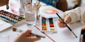 A group of older adults enjoying a watercolor painting class in a well-lit community studio.