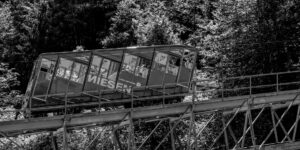 A modern funicular train climbing a scenic mountain railway.