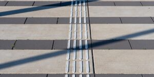 Modern city crosswalk featuring updated high-contrast tactile paving for improved pedestrian safety.