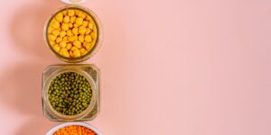 A variety of fresh, nutrient-rich foods including salmon, chickpeas, and vegetables on a wooden table.