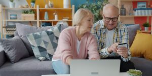 A senior couple using smart home technology to manage energy efficiency.