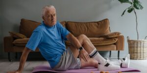 A senior adult performing seated hip exercises at home for stability.