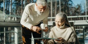 An elderly couple enjoying a coffee in a historic, accessible European plaza.