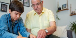 A focused older adult working on a jigsaw puzzle in a sunlit room.