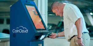 A senior adult interacting with a modern voice-activated kiosk in a public space.
