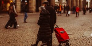 An active senior couple walking through a historic city square.