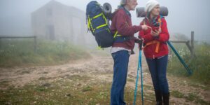 An active senior couple planning their travel route in a scenic, accessible plaza.