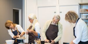 A group of older adults participating in a pottery workshop.