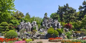 A scenic view of a beautifully landscaped public garden with wide, accessible pathways perfect for comfortable walking.