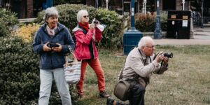 A group of active seniors enjoying bird-watching in a park.