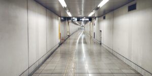 Modern transit hub floor with high-contrast tactile paving strips.